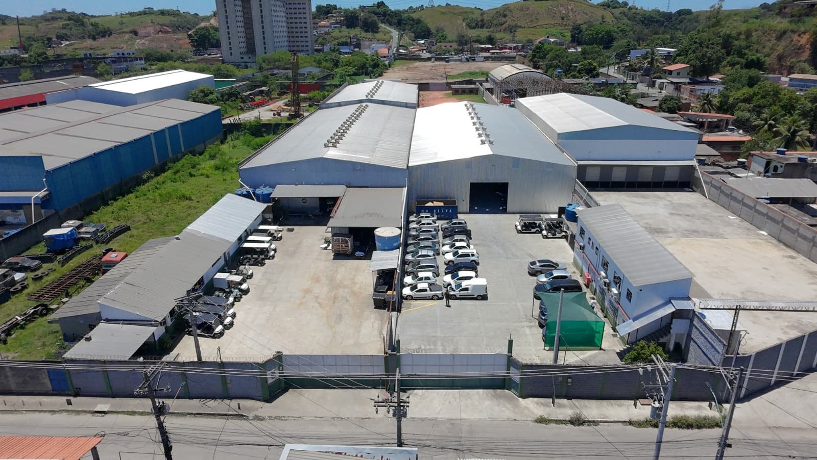 Vista aérea da estrutura própria de manutenção da Car Station, com galpões e frota no pátio